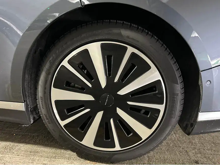Close-up of a silver car's wheel featuring a black and silver two-tone alloy rim with distinctive spoke design.