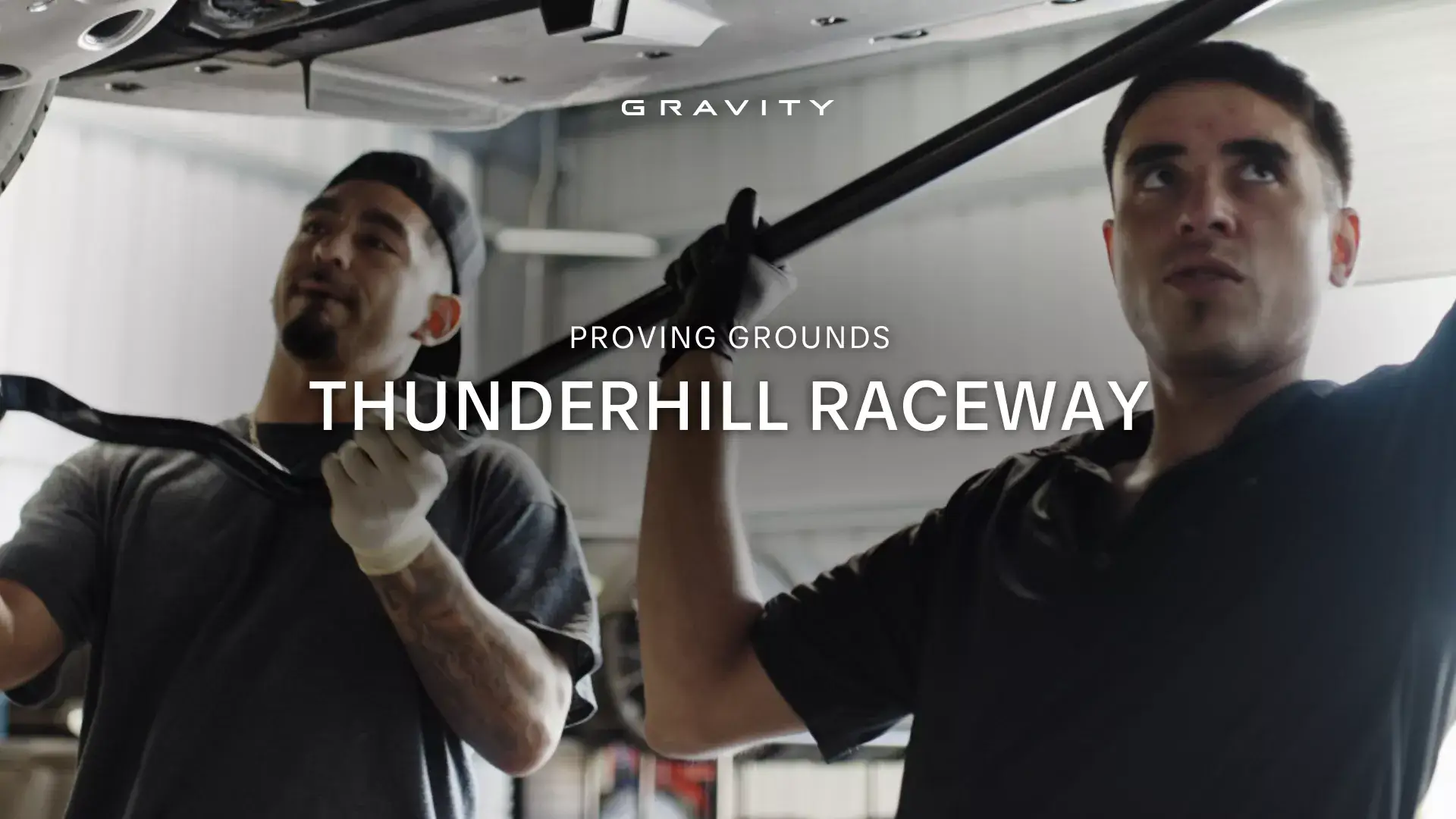 Two people in a training facility with text overlay "GRAVITY PROVING GROUNDS THUNDERHILL RACEWAY"