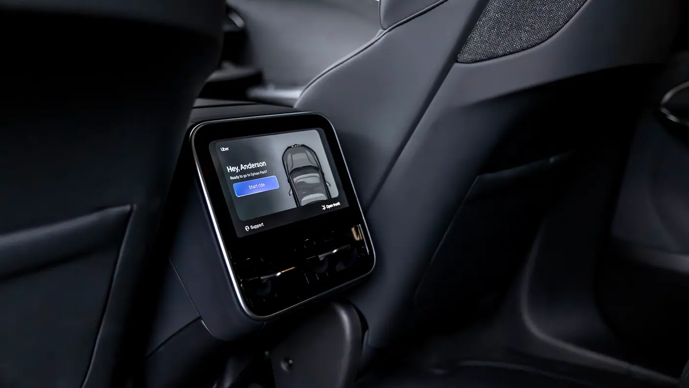 Uber touchscreen display mounted in a car's rear seat showing "Hey Anderson" greeting and "START RIDE" button.