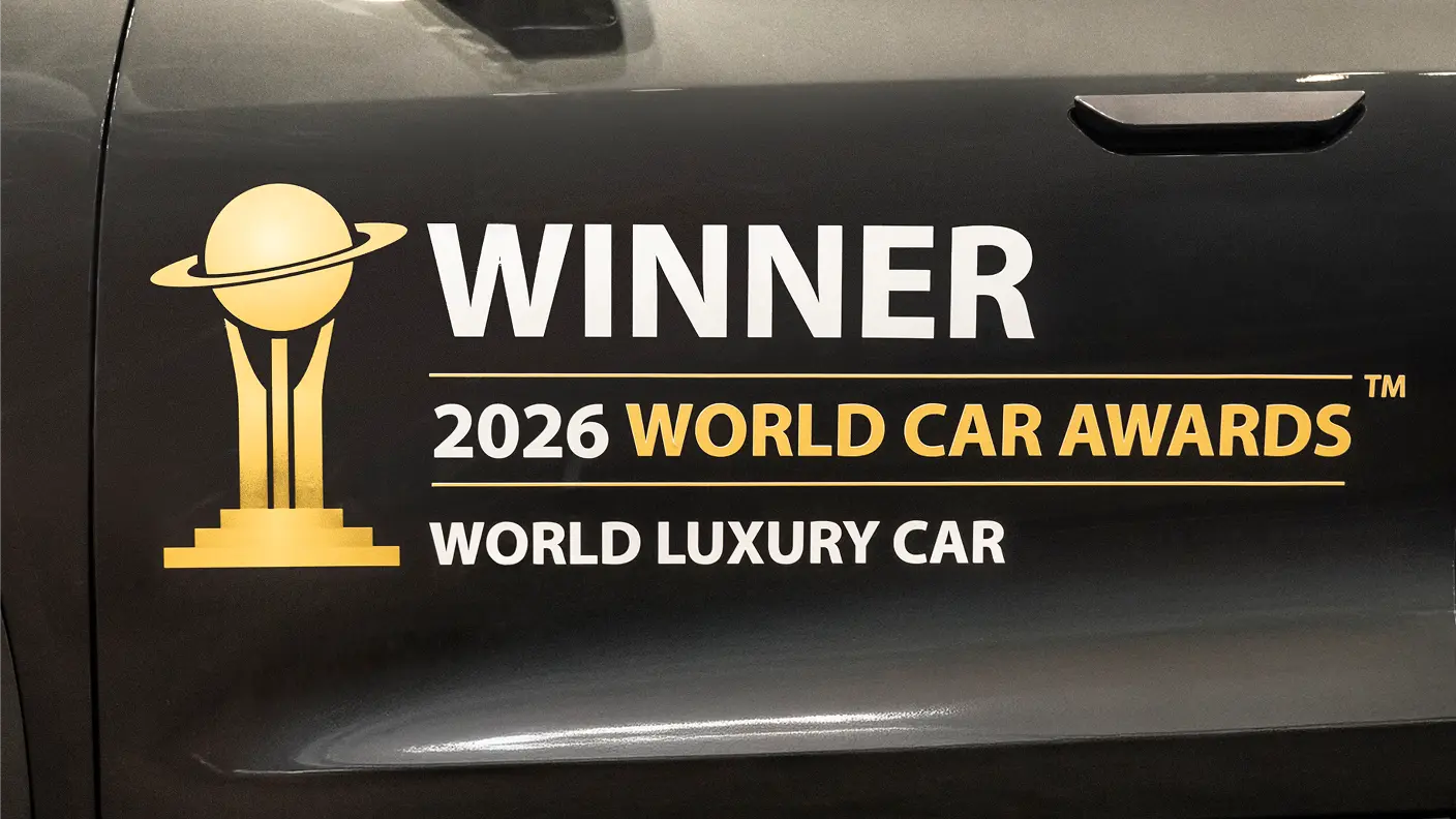 Black car door with gold trophy logo displaying "WINNER 2026 WORLD CAR AWARDS WORLD LUXURY CAR"