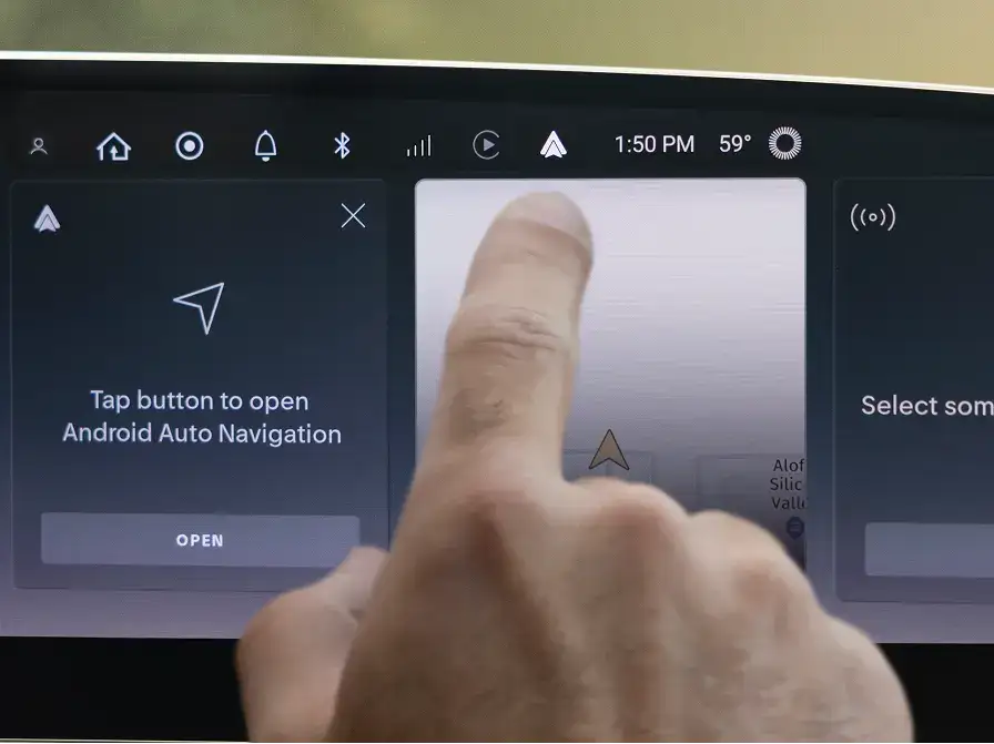 Finger pressing "Open" button on car dashboard touchscreen to access Android Auto Navigation at 1:50 PM.