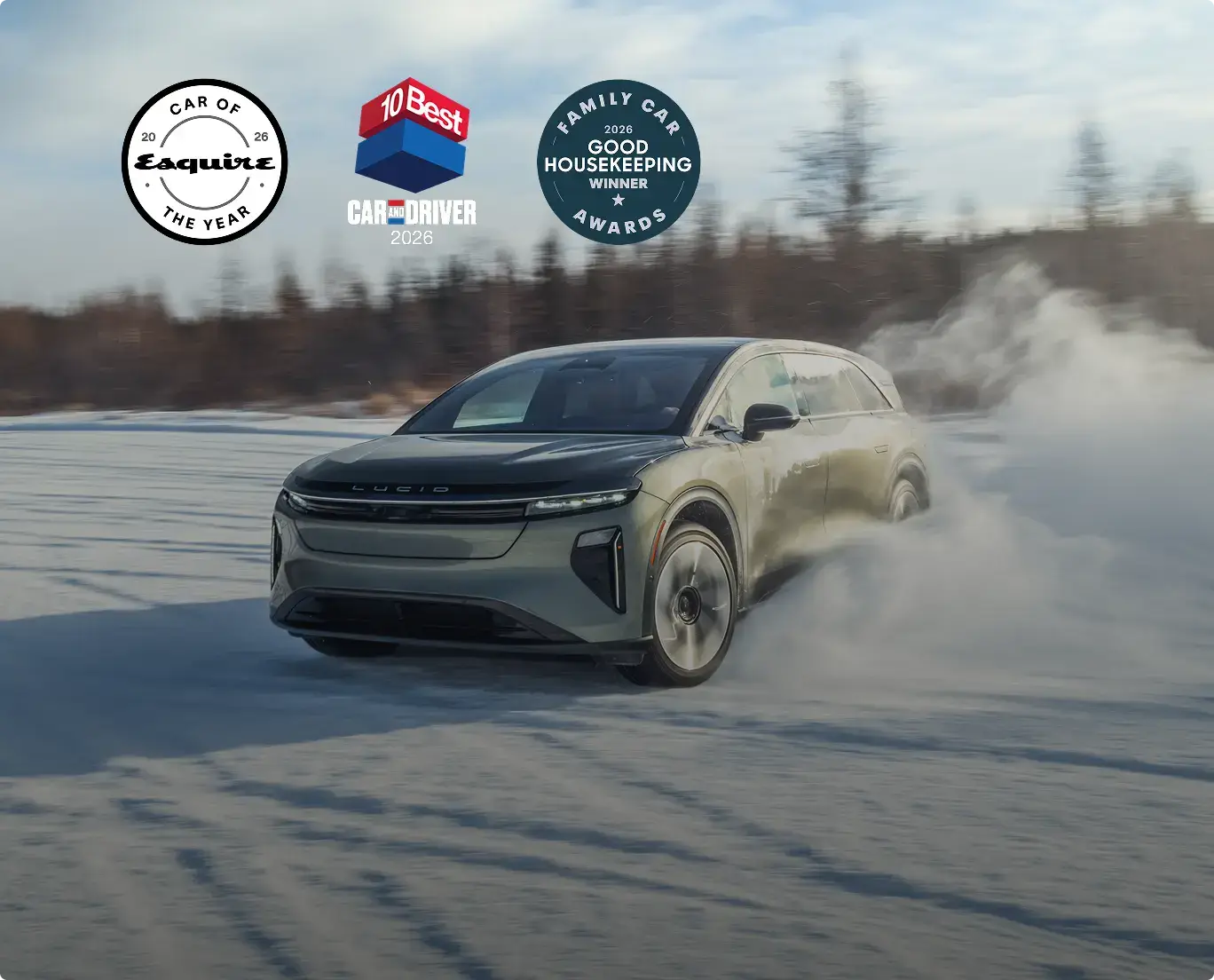 Lucid electric vehicle drifting on snow with award badges from Esquire, Car and Driver, and Good Housekeeping visible above.