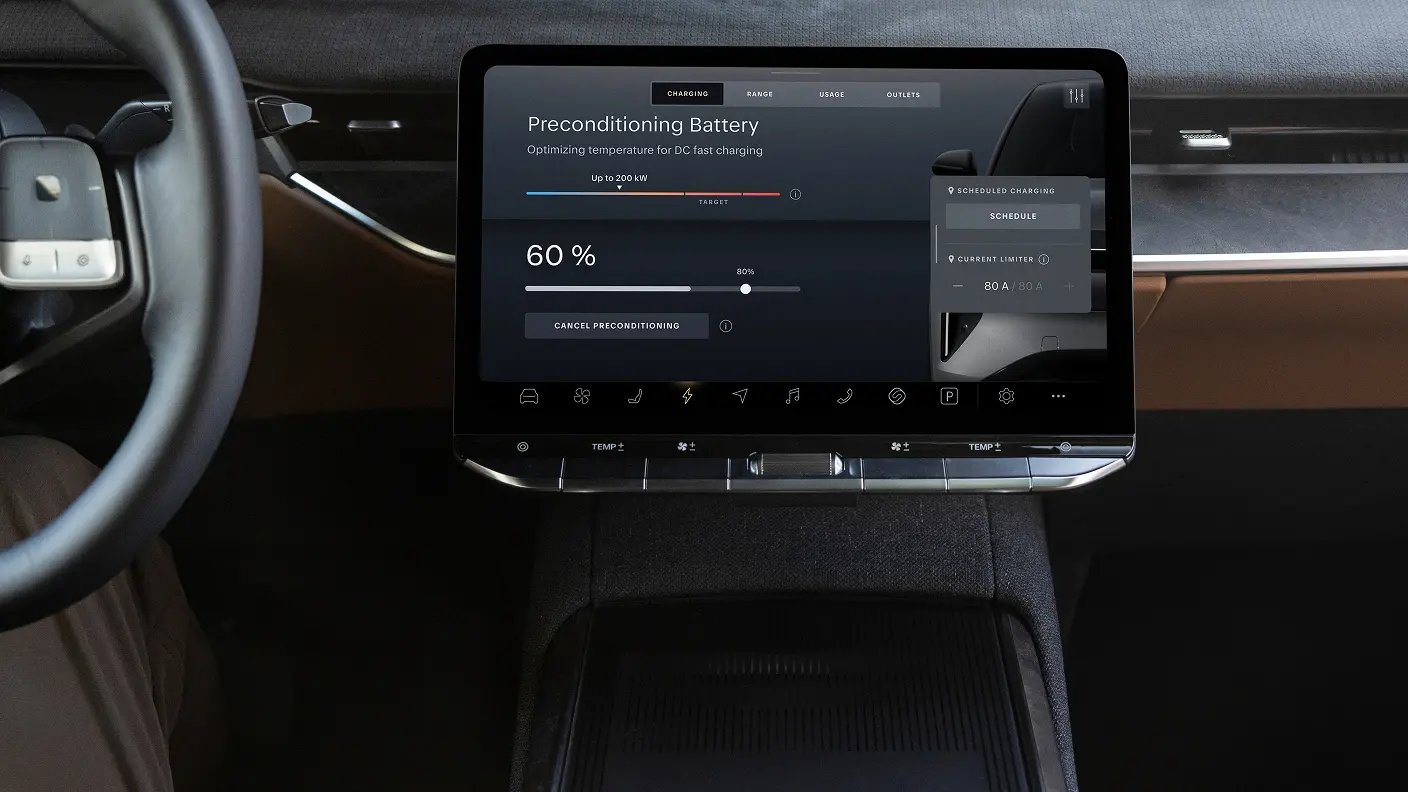Écran tactile de la console centrale du VÉ affichant un écran de recharge « Préconditionnement de la batterie » à 60 % avec une interface utilisateur sombre.