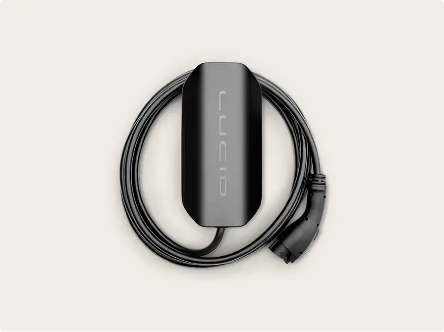 Black Lucid electric vehicle charging cable with connector, coiled in a circle against a light beige background.