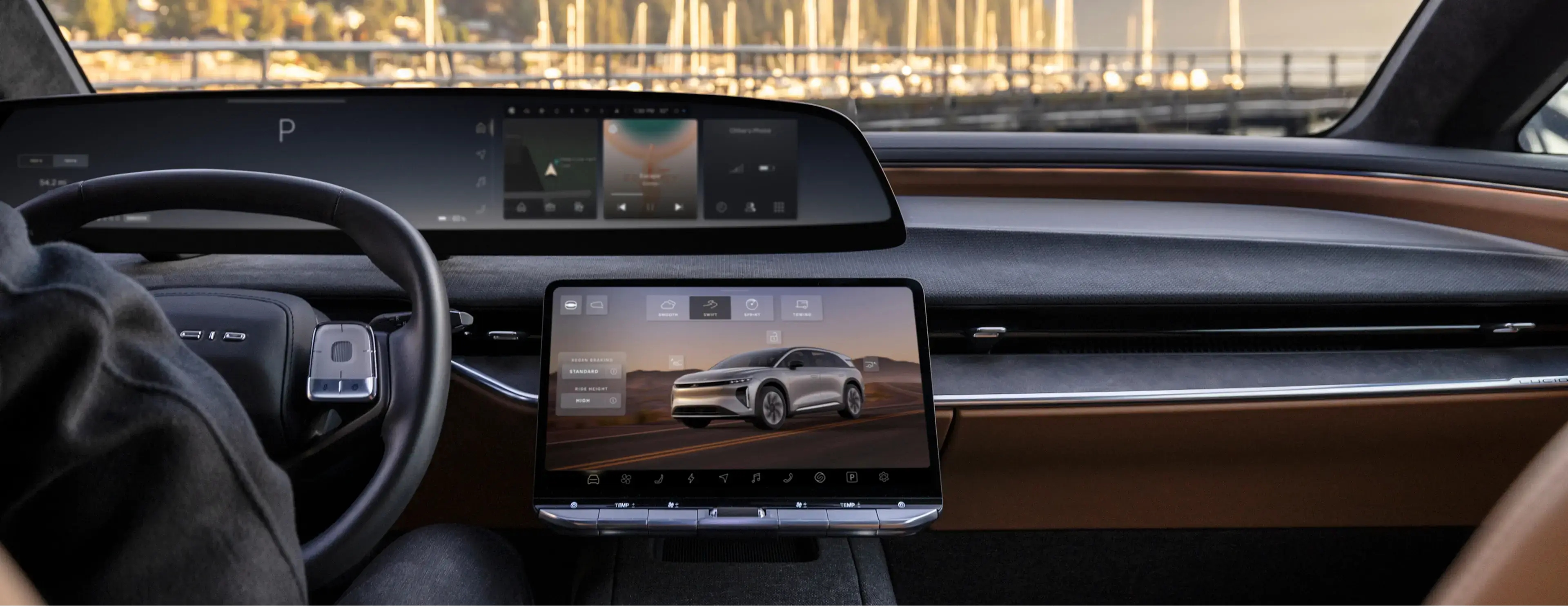Modern car interior with dual digital displays showing infotainment and vehicle controls, marina visible through windshield.