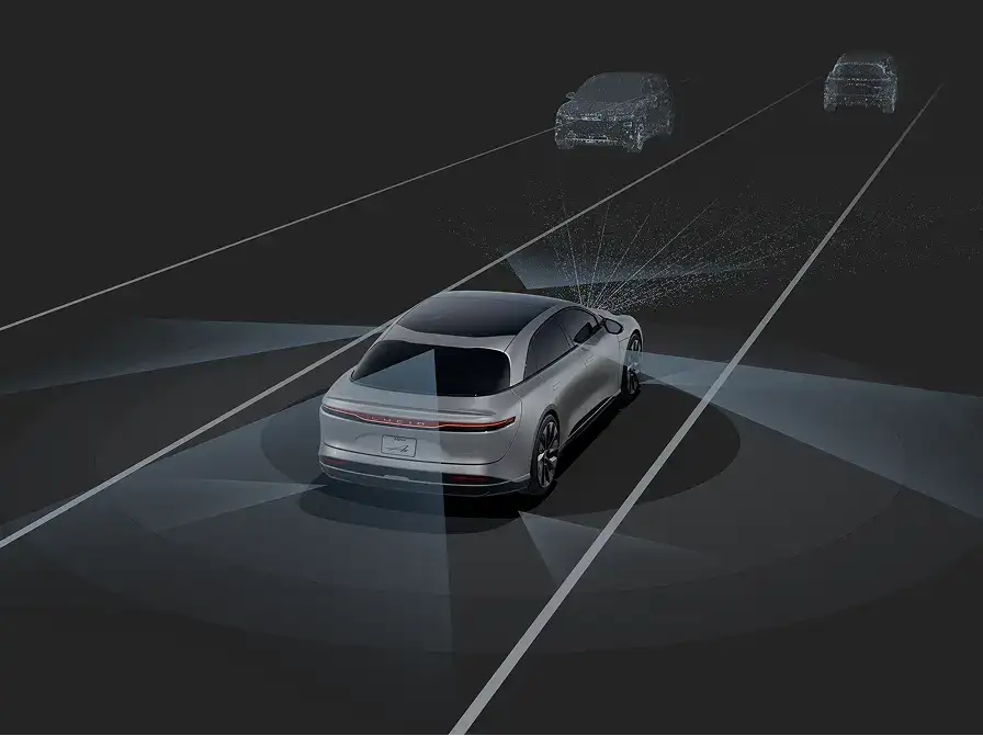 Silver electric car on dark road with advanced sensor visualization showing vehicle detection capabilities ahead.
