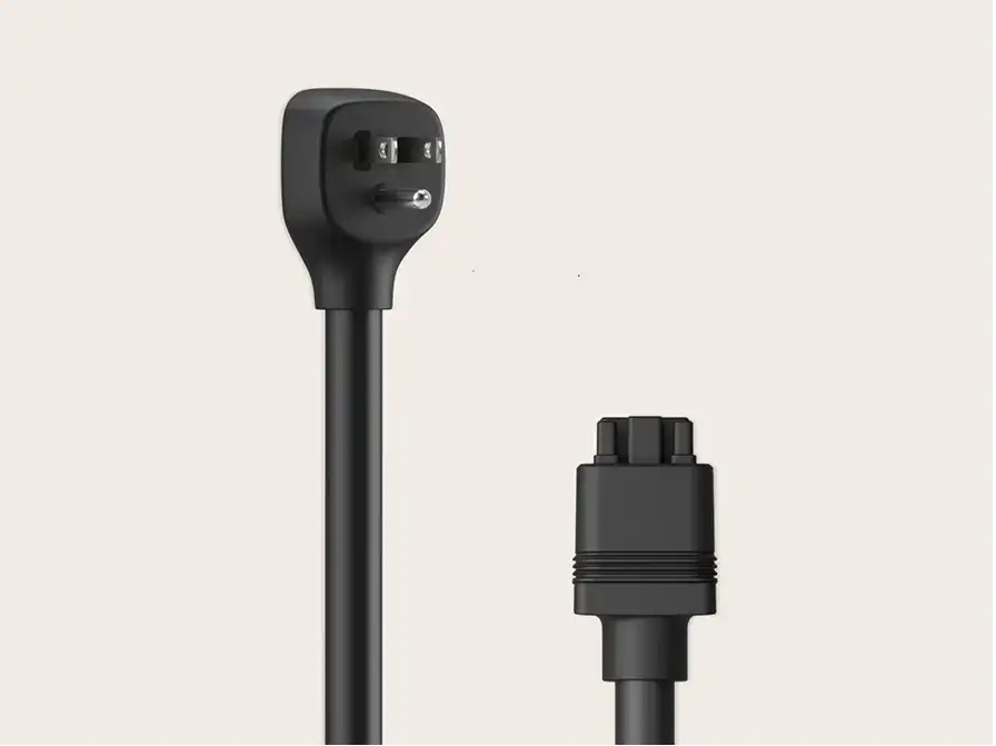 Black power cable with a flat angled three-prong plug on one end and a round connector on the other, on a light background.
