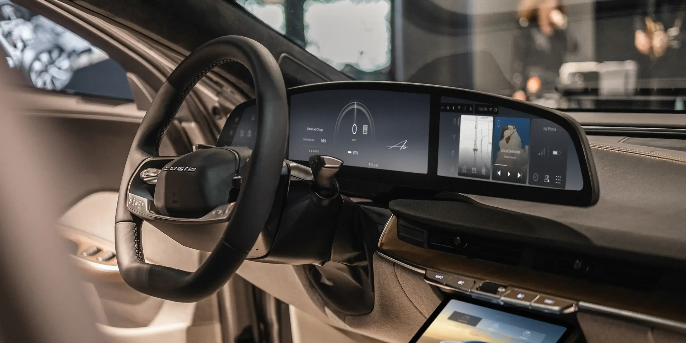 Modern luxury car interior with digital dashboard display, touchscreen console, and leather steering wheel in beige and black.