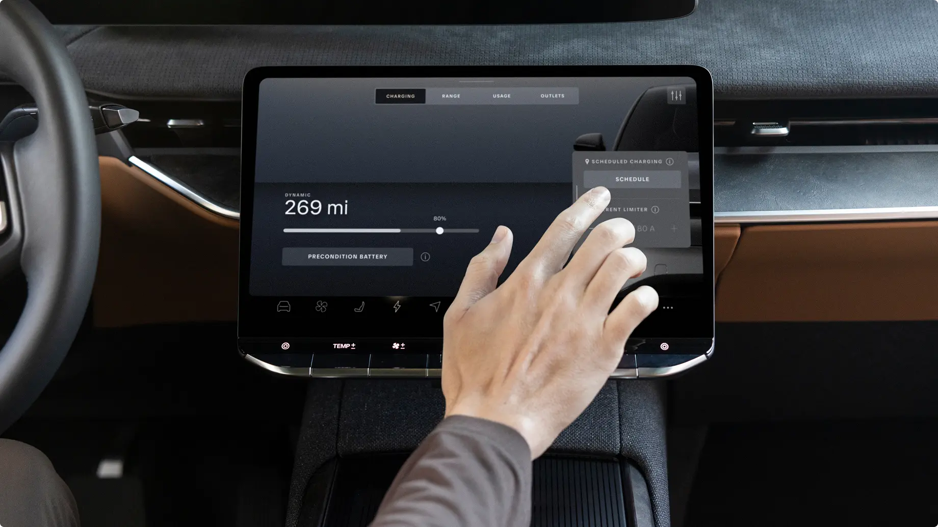 Hand adjusting settings on electric vehicle touchscreen display showing 269 miles of range at 80% battery charge.