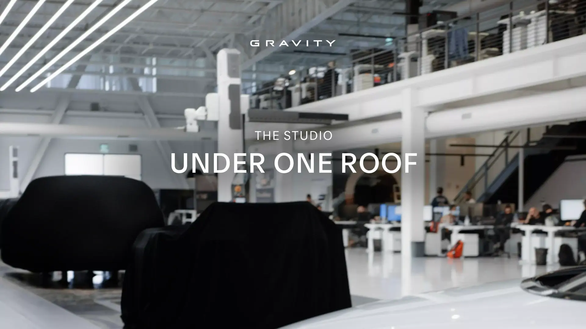 Modern open-concept studio workspace with "GRAVITY" logo and "THE STUDIO UNDER ONE ROOF" text overlay.