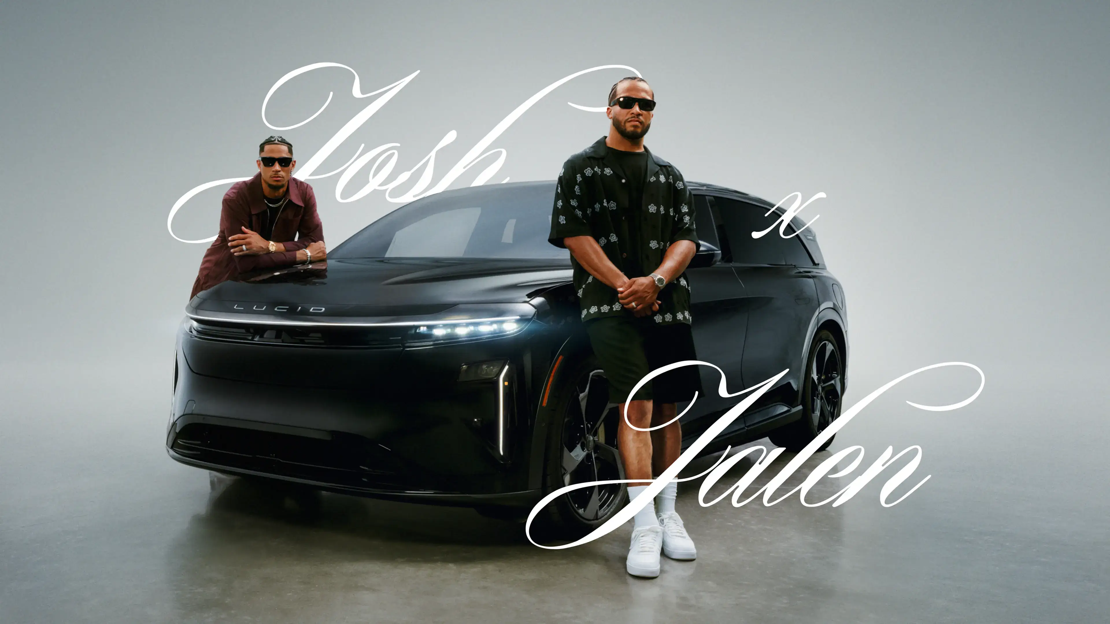 Josh Hart and Jalen Brunson standing next to Lucid Gravity