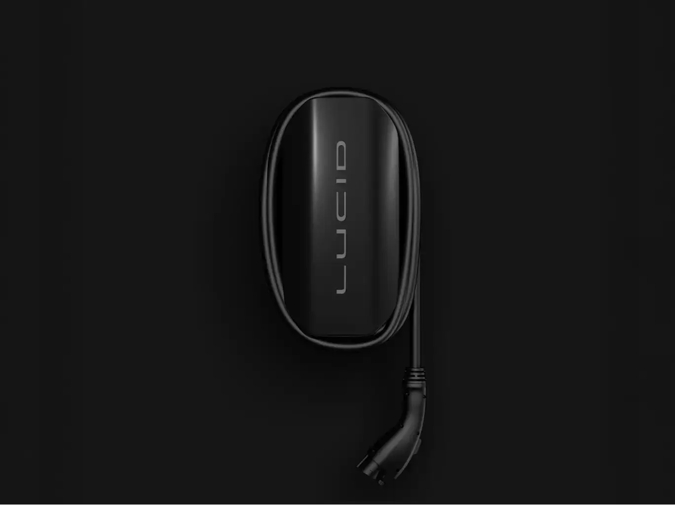 Sleek black wireless charging device with minimalist design and attached cable against dark background.