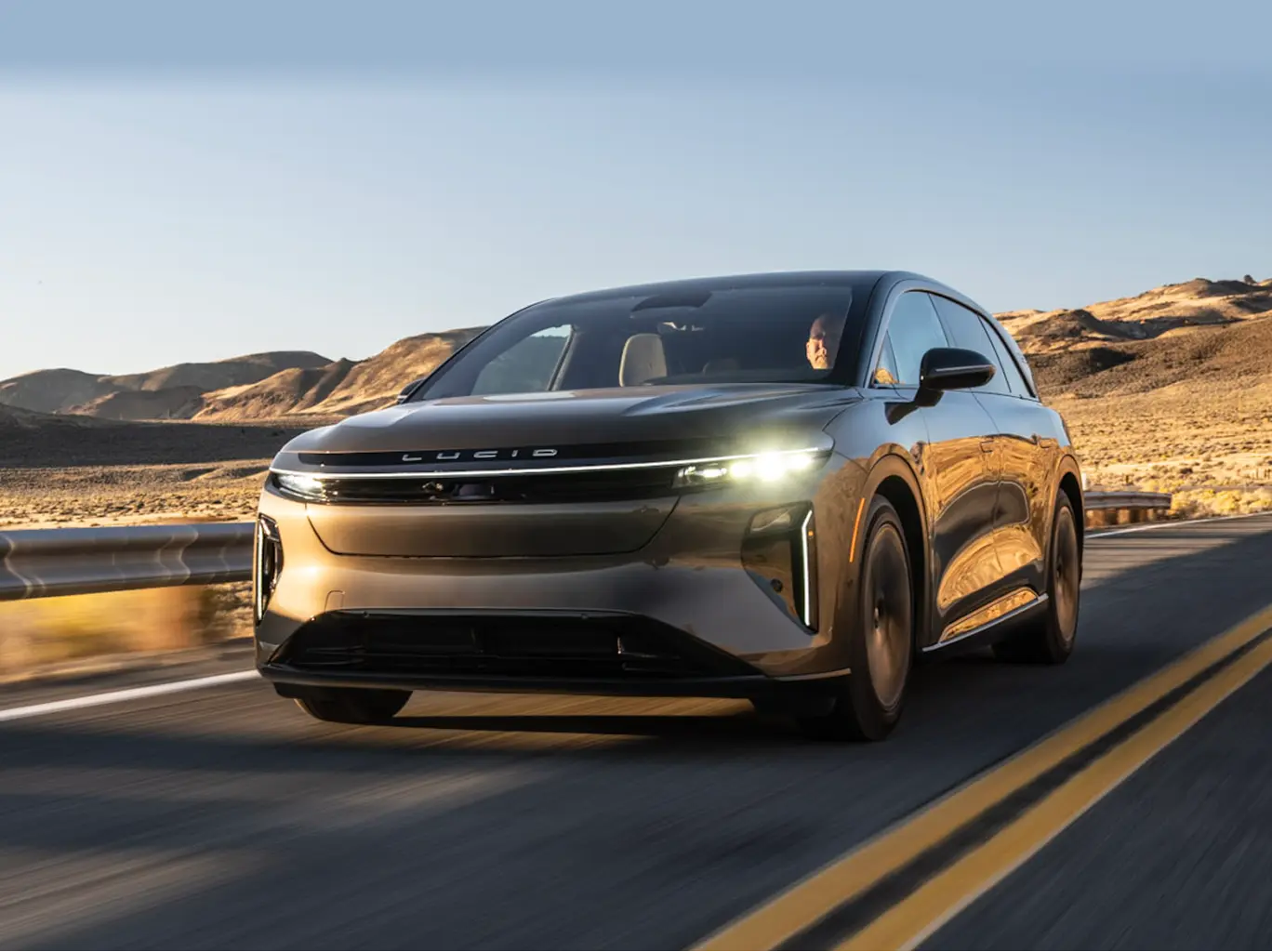 The Lucid Gravity electric SUV driving on a desert highway.