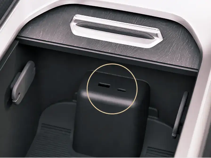 Black storage compartment in a vehicle console shown from two angles, with silver trim surrounding the compartment.