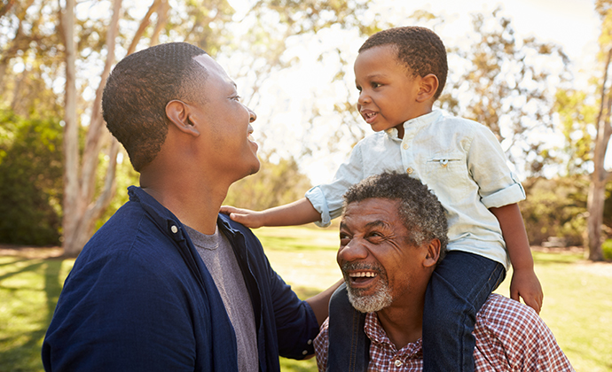 A multigenerational family smiling at each other.