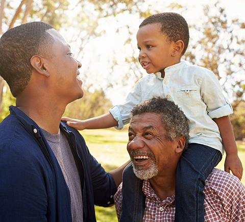 A multigenerational family smiling at each other.