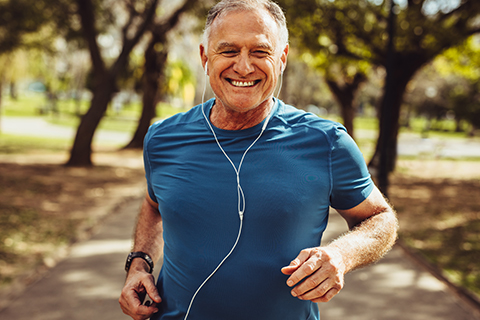 A picture of a man running outside with headphones.