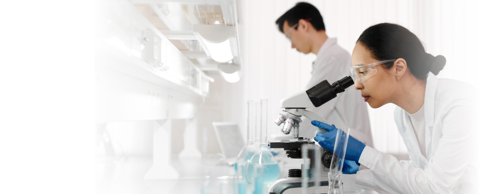 scientists looking through a microscope at a lab