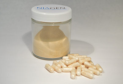 Pills of Niagen on a flat surface next to a clear glass bottle.