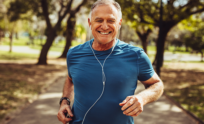 A picture of a man running outside with headphones.