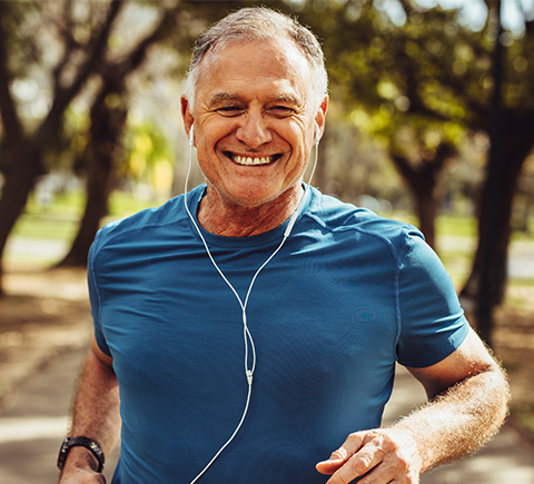 A picture of a man running outside with headphones.