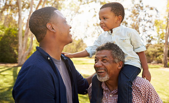 A multigenerational family smiling at each other.