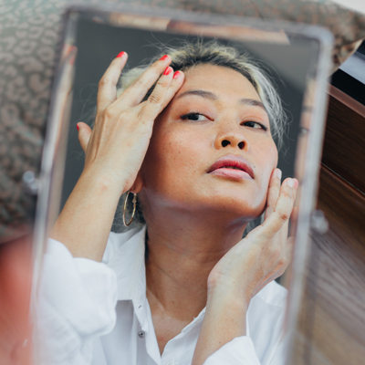 woman looking at the mirror for wrinkles
