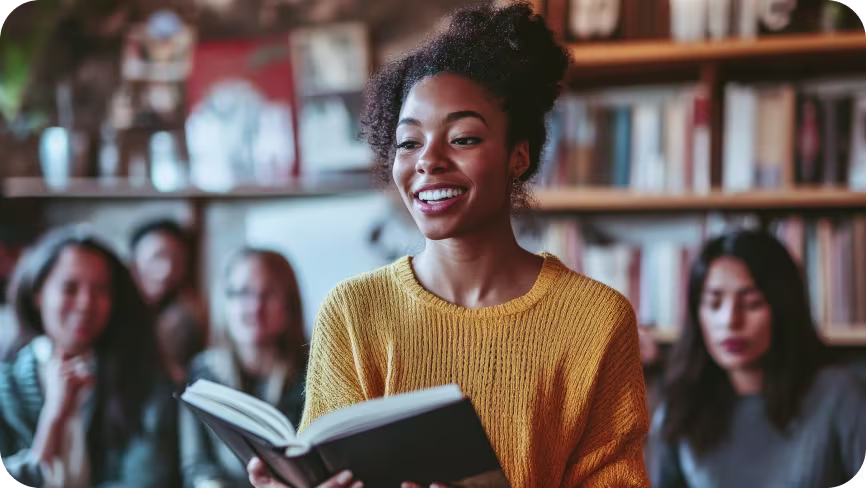 Women reading a book to a group of people 
