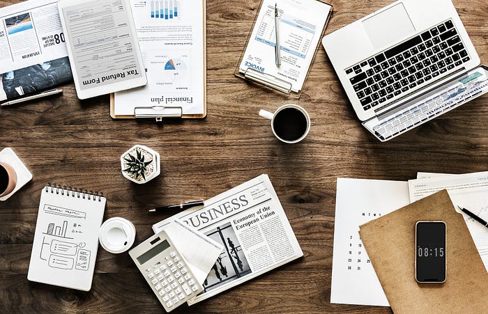 Automating Document Processing With AI – desk setup with laptop, newspaper, and coffee (banner)