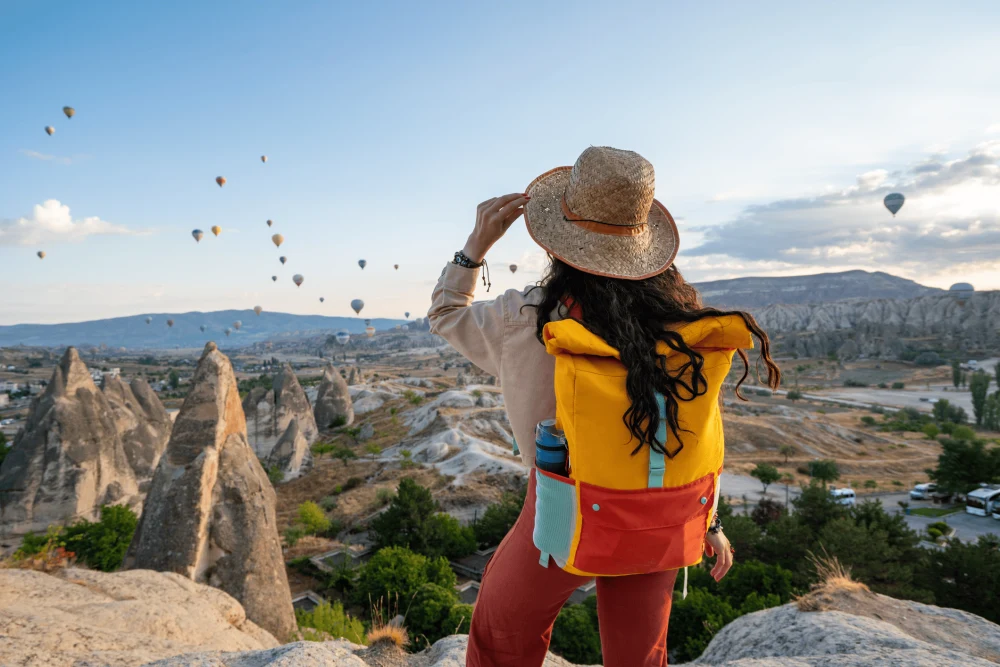 Paesaggio Turchia, Cappadocia, con ragazza che osserva le mongolfiere in volo