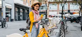 Assicurazione assistenza stradale per bici ed e-bike, ragazza che sta prendendo una bici in bike sharing