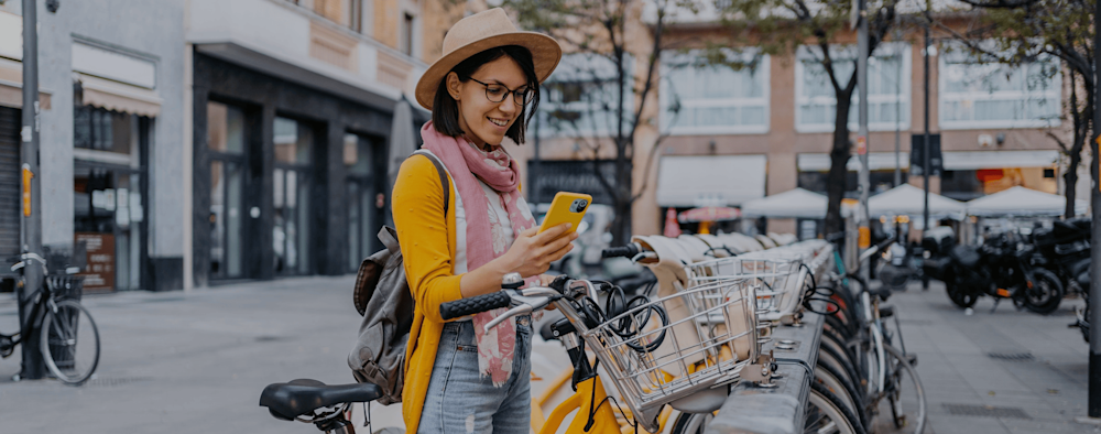 Assicurazione assistenza stradale per bici ed e-bike, ragazza che sta prendendo una bici in bike sharing