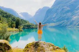 consigli di viaggio settembre: ragazza di spalle che guarda un lago alpino