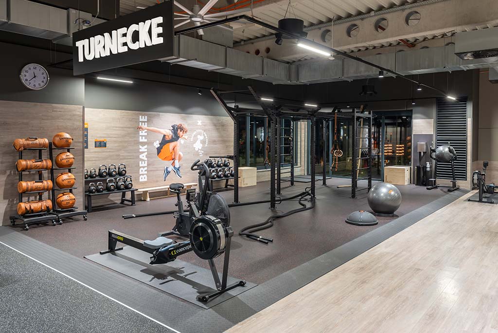 Spezielle Turnecke im FitX Fitnessstudio Augsburg-Lechhausen. Im Zentrum steht ein großes Turngerät mit Sprossenleitern, Ringen, Battle-Ropes und Hangelmöglichkeiten. An der Seite befinden sich Medizinbälle, Kettlebells sowie Plyo-Boxen aus Holz.