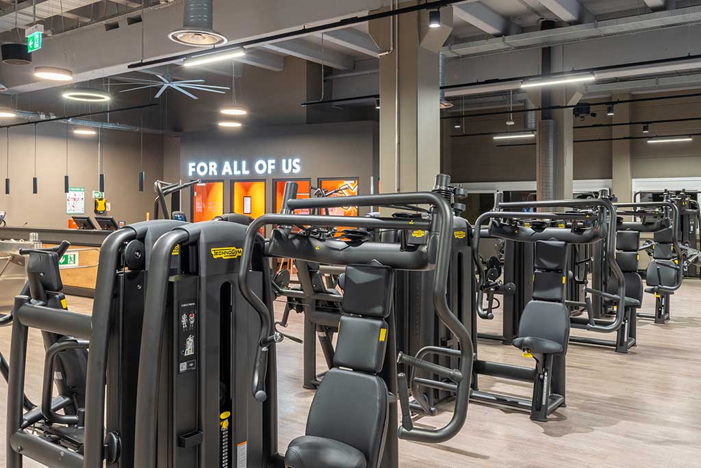 Gerätebereich im FitX Fitnessstudio Nürnberg-Zabo mit verschiedenen Kraftgeräten. Der Raum ist im industriellen Design gestaltet, mit offenen Deckenstrukturen und hellen Böden.