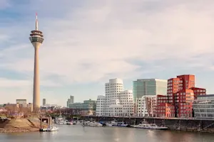 Panoramaaufnahme von Düsseldorf bei Tag mit Blick auf den Rhein, den Rheinturm und die Gehry-Bauten.