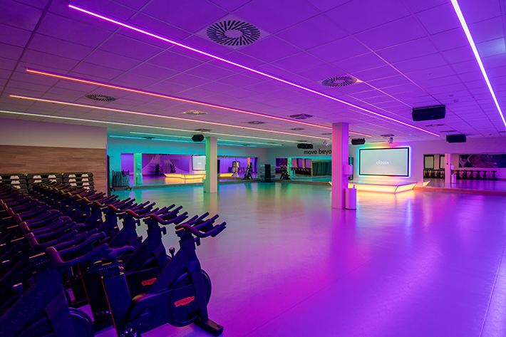 Gerätebereich im FitX Fitnessstudio Augsburg-Lechhausen mit verschiedenen Kraftgeräten. Der Raum ist im industriellen Design gestaltet, mit offenen Deckenstrukturen und hellen Böden.