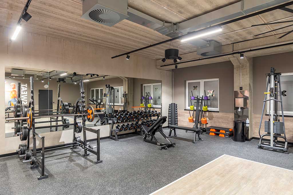 Abgetrennter Freihantelbereich für Frauen im FitX Fitnessstudio Leipzig-Neulindenau, ausgestattet mit Kurzhanteln, Kraftgeräten und großen Spiegelfronten.