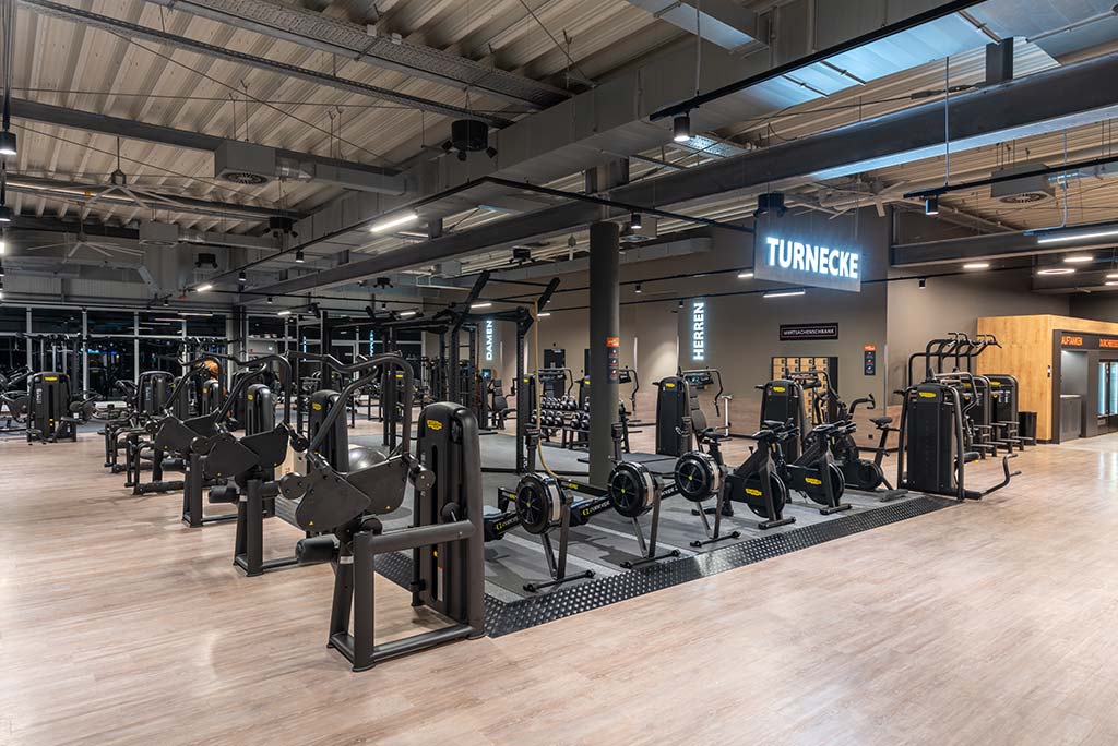 Spezielle Turnecke im FitX Fitnessstudio Dortmund-Phoenix See. Im Zentrum steht ein großes Turngerät mit Sprossenleitern, Ringen, Battle-Ropes und Hangelmöglichkeiten. An der Seite befinden sich Medizinbälle, Kettlebells sowie Plyo-Boxen aus Holz.