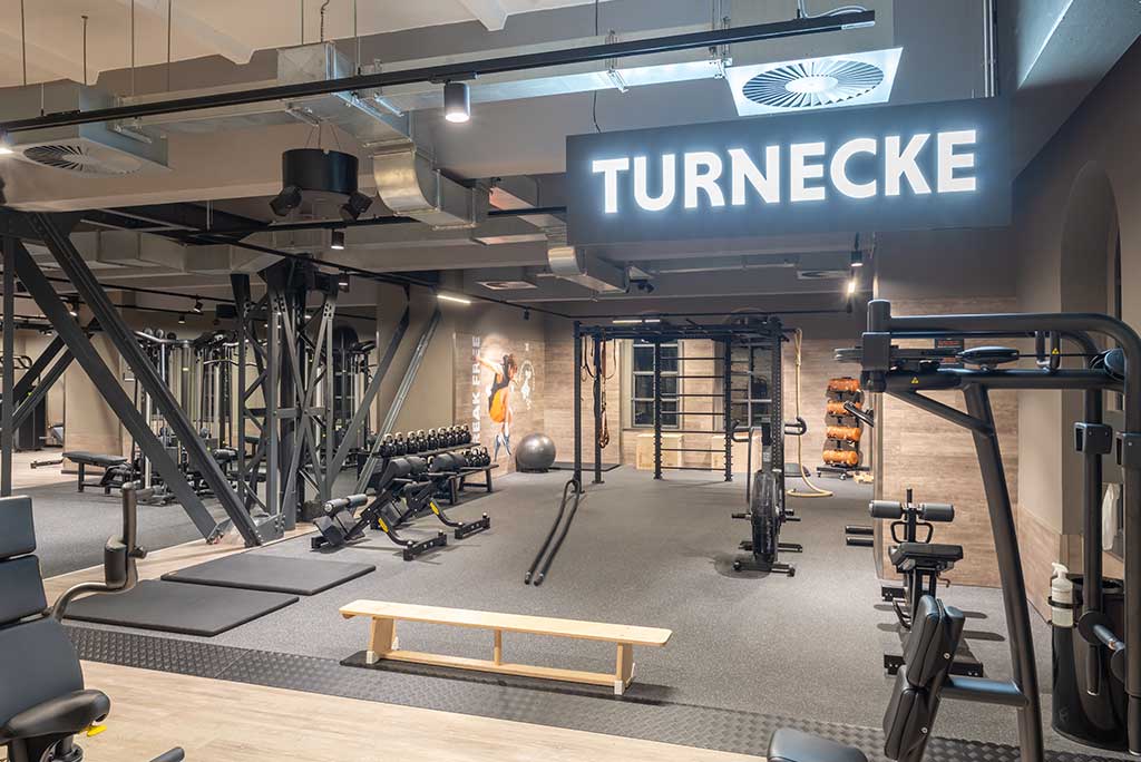Spezielle Turnecke im FitX Fitnessstudio Berlin-Moabit. Im Zentrum steht ein großes Turngerät mit Sprossenleitern, Ringen, Battle-Ropes und Hangelmöglichkeiten. An der Seite befinden sich Medizinbälle, Kettlebells sowie Plyo-Boxen aus Holz.