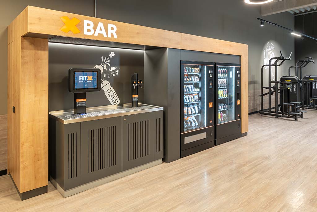 Abgetrennter Lounge-Bereich im FitX Fitnessstudio Augsburg-Lechhausen mit verschiedenen Sitzmöglichkeiten. Der Bereich ist hell, freundlich und im industriellen Design gestaltet.