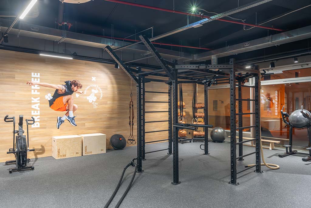 Spezielle Turnecke im FitX Fitnessstudio Böblingen-Zentrum. Im Zentrum steht ein großes Turngerät mit Sprossenleitern, Ringen, Battle-Ropes und Hangelmöglichkeiten. An der Seite befinden sich Medizinbälle, Kettlebells sowie Plyo-Boxen aus Holz.