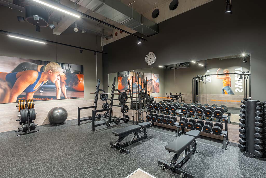 Abgetrennter Freihantelbereich für Frauen im FitX Fitnessstudio Augsburg-Lechhausen, ausgestattet mit Kurzhanteln, Kraftgeräten und großen Spiegelfronten.