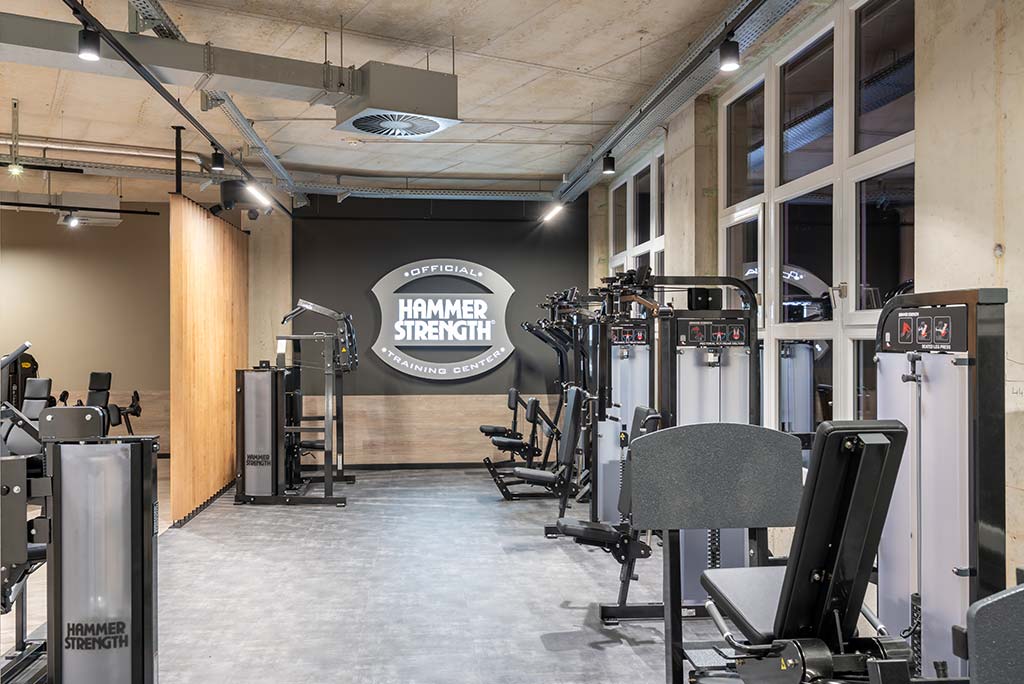 Zirkel-Bereich im FitX Fitnessstudio Mülheim-Stadtmitte, in dem verschiedene Trainingsgeräte kreisförmig angeordnet sind. Über den Geräten hängt ein großer Leuchtring, der in grün oder rot leuchtet und die Übungsdauer anzeigt.