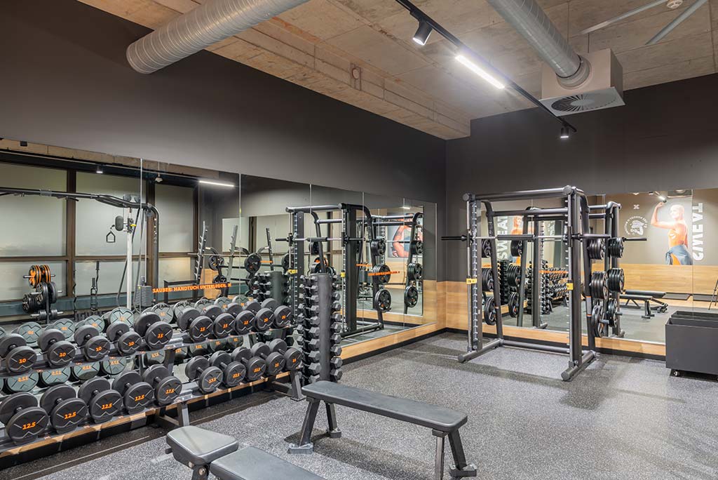 Abgetrennter Freihantelbereich für Frauen im FitX Fitnessstudio Essen-Bergerhausen, ausgestattet mit Kurzhanteln, Kraftgeräten und großen Spiegelfronten.