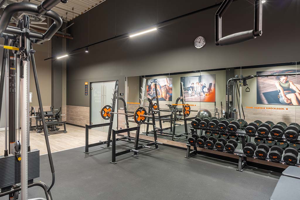 Abgetrennter Freihantelbereich für Frauen im FitX Fitnessstudio Dortmund-Phoenix See, ausgestattet mit Kurzhanteln, Kraftgeräten und großen Spiegelfronten.