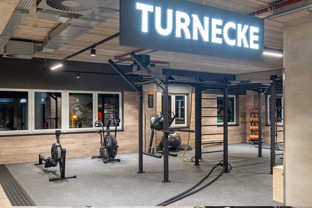 Spezielle Turnecke im FitX Fitnessstudio Leipzig-Neulindenau. Im Zentrum steht ein großes Turngerät mit Sprossenleitern, Ringen, Battle-Ropes und Hangelmöglichkeiten. An der Seite befinden sich Medizinbälle, Kettlebells sowie Plyo-Boxen aus Holz.