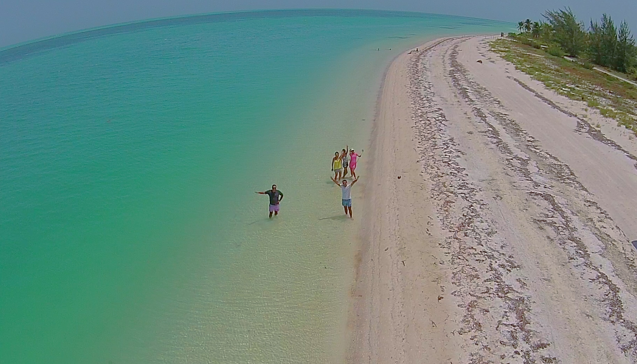 A birds eye view of a group of people on the shore of Holbox looking up