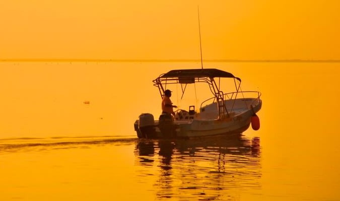 A fisherman in his fishingboat at dawn in Holbox's Laguna Conil