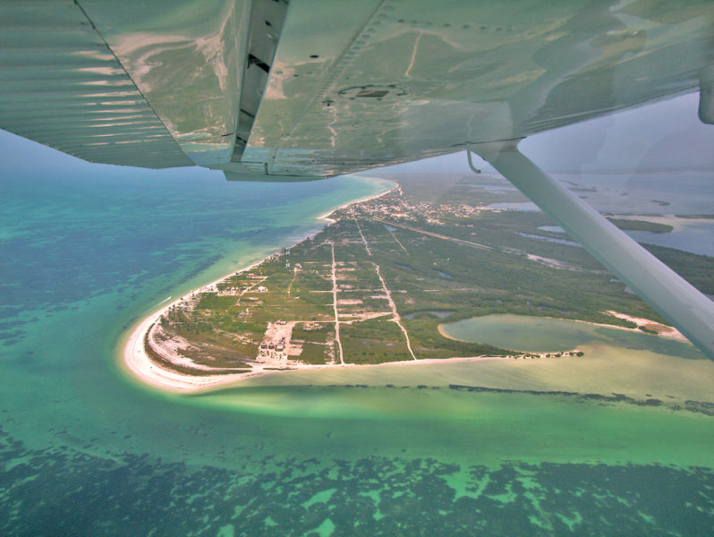 Vista desde una avioneta del lado babor donde se ve el ala y debajo la playa de Punta Cocos en la Isla Holbox.  Photo Credit: Šarūnas Burdulis